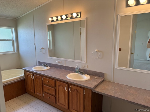 bathroom with a tub to relax in, tile patterned flooring, a textured ceiling, ornamental molding, and vanity