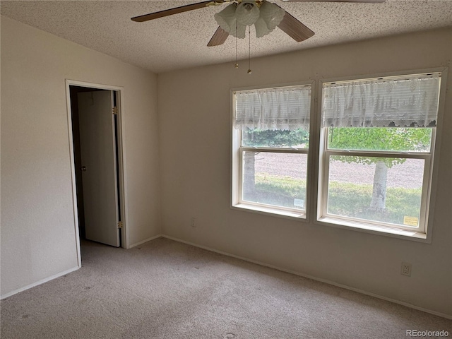 spare room featuring a textured ceiling, ceiling fan, vaulted ceiling, and light carpet