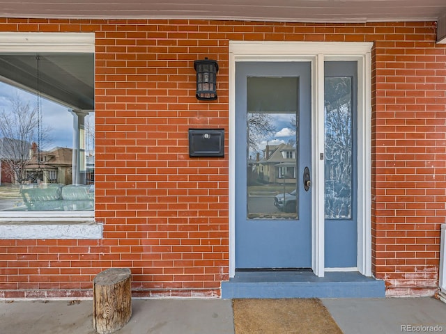 view of exterior entry with brick siding