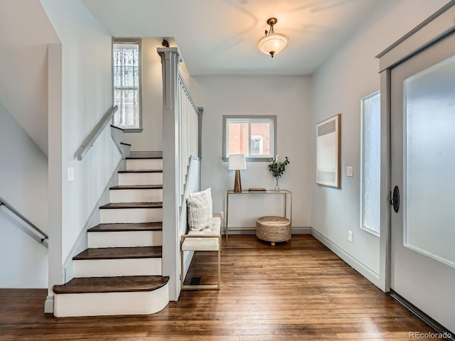 foyer featuring stairs, baseboards, and wood finished floors