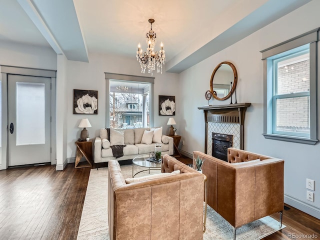 living area with a tile fireplace, baseboards, and hardwood / wood-style floors