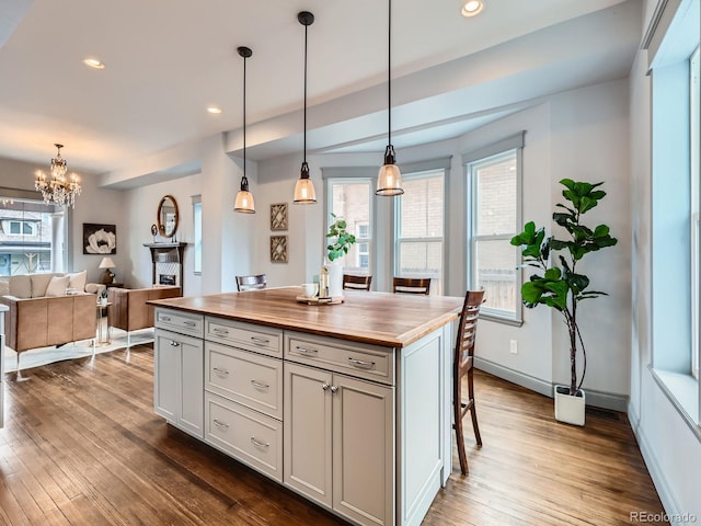 kitchen featuring dark wood-type flooring, recessed lighting, butcher block counters, and plenty of natural light