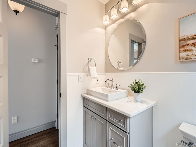 bathroom featuring a baseboard heating unit, wood finished floors, and vanity