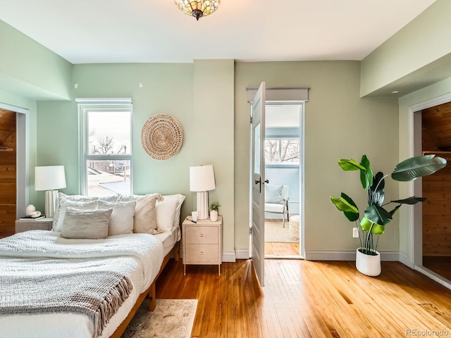 bedroom with wood-type flooring and baseboards