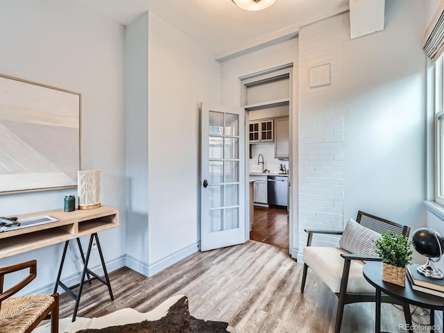 office space with light wood-style floors, baseboards, and a sink