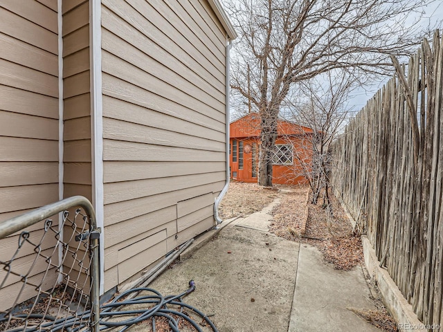 view of side of home with an outdoor structure and fence