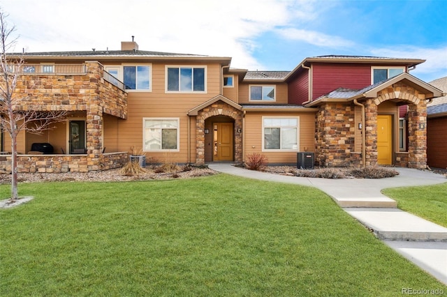 view of front of property with stone siding, a chimney, a front lawn, and exterior kitchen