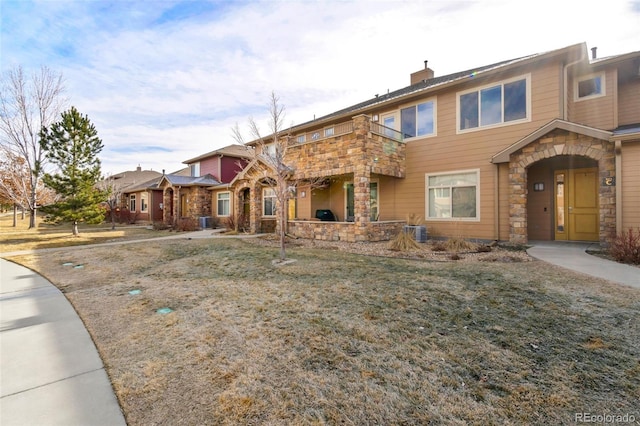 view of front of home with central air condition unit and a front lawn