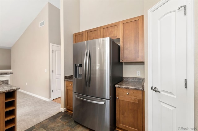 kitchen featuring stainless steel fridge and high vaulted ceiling