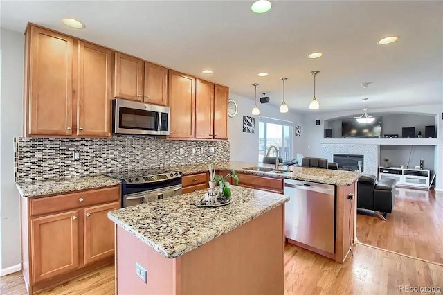 16893 Trail View Cir, Parker, CO 80134 - kitchen featuring stainless steel appliances, a sink, a peninsula, decorative backsplash, and light wood-type flooring