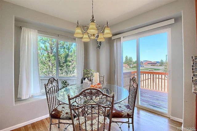 16893 Trail View Cir, Parker, CO 80134 - dining space featuring a chandelier, baseboards, wood finished floors, and healthy amount of natural light
