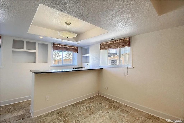 16893 Trail View Cir, Parker, CO 80134 - kitchen featuring baseboards, a textured ceiling, a raised ceiling, and pendant lighting