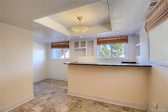 16893 Trail View Cir, Parker, CO 80134 - kitchen with a textured ceiling, baseboards, pendant lighting, a tray ceiling, and a sink