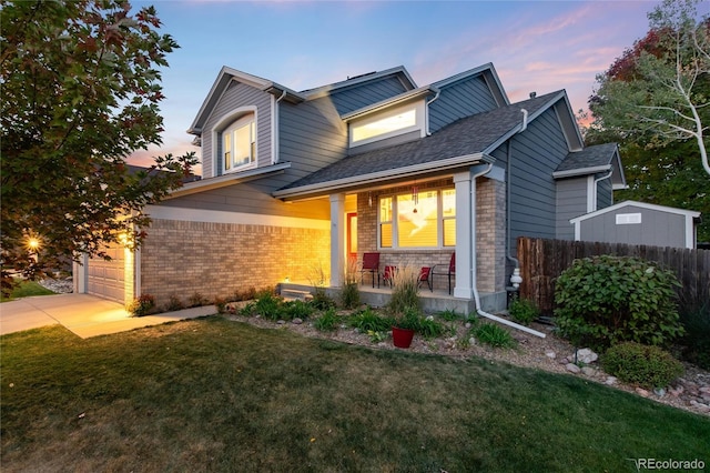 craftsman-style home featuring a lawn, covered porch, and a garage