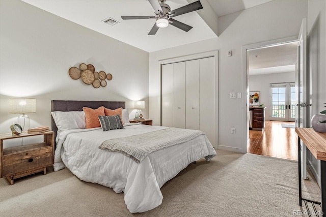 carpeted bedroom with visible vents, baseboards, a closet, and a ceiling fan