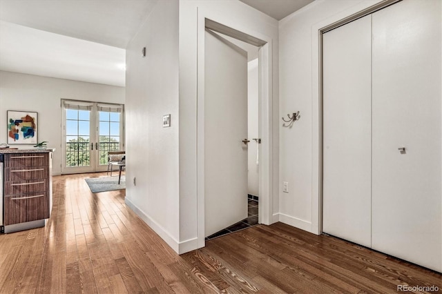 hallway with wood finished floors, baseboards, and french doors