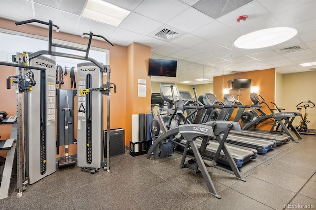 gym with a paneled ceiling and visible vents