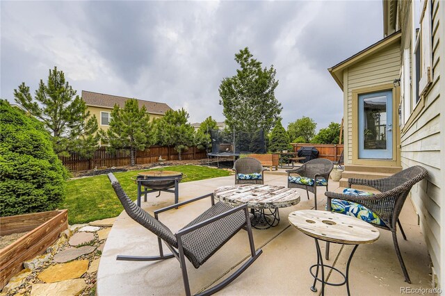 3944 Trail Stone Cir, Castle Rock, CO 80108 - fenced backyard with a trampoline, a patio, an outdoor hangout area, and entry steps