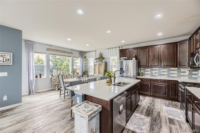3944 Trail Stone Cir, Castle Rock, CO 80108 - kitchen featuring stainless steel appliances, light wood-type flooring, light countertops, dark brown cabinets, and recessed lighting