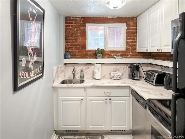 1351 N Franklin St, Denver, CO 80218 - kitchen featuring stainless steel dishwasher, white cabinetry, a textured ceiling, light stone countertops, and brick wall
