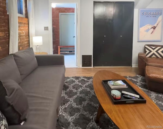 1351 N Franklin St, Denver, CO 80218 - living area featuring brick wall and wood finished floors