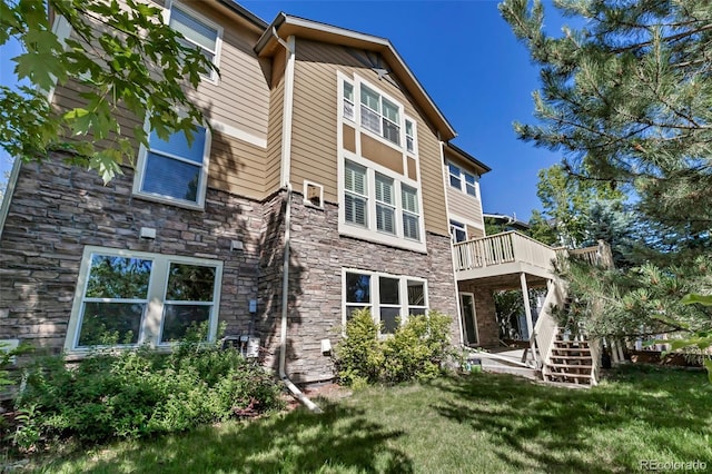 10646 Amesbury Way, Highlands Ranch, CO 80126 - back of house with stone siding, a deck, a yard, and stairs