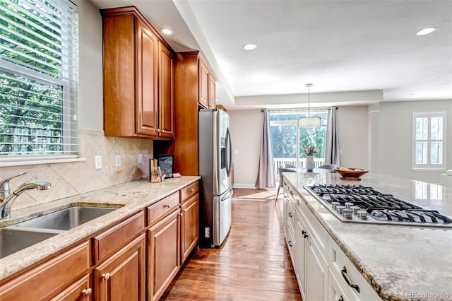 10646 Amesbury Way, Highlands Ranch, CO 80126 - kitchen with appliances with stainless steel finishes, wood finished floors, light stone countertops, brown cabinets, and recessed lighting