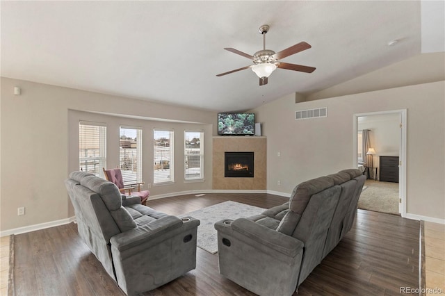 living room with a fireplace, vaulted ceiling, dark hardwood / wood-style floors, and ceiling fan