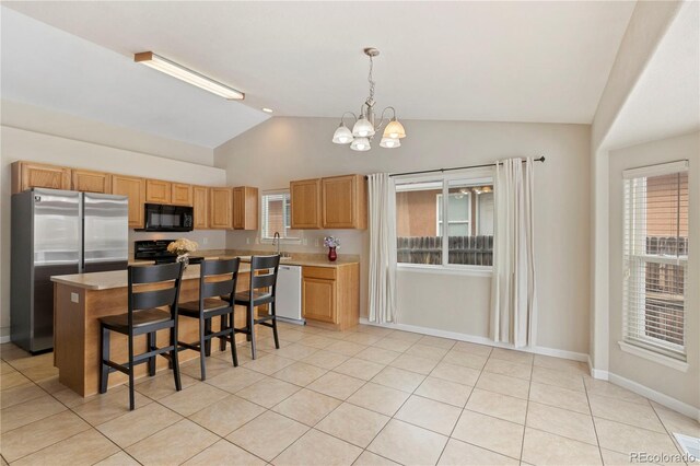 kitchen featuring pendant lighting, a breakfast bar area, stainless steel fridge, a center island, and white dishwasher