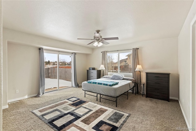 carpeted bedroom featuring ceiling fan, access to exterior, and a textured ceiling