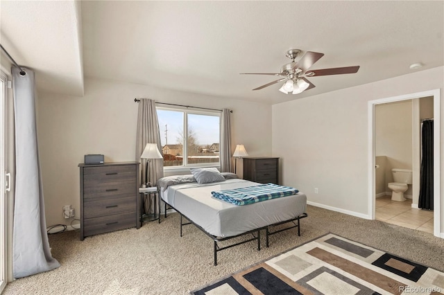 bedroom featuring light carpet, ceiling fan, and ensuite bathroom