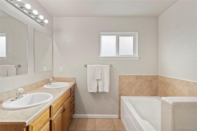 bathroom featuring vanity, a bath, and tile patterned flooring