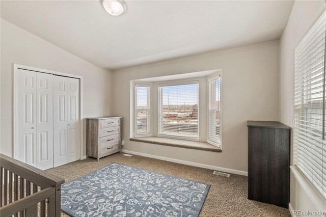 bedroom featuring lofted ceiling, a closet, and carpet flooring