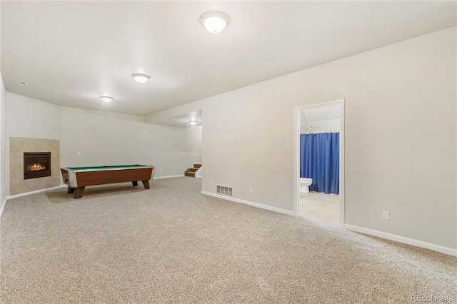 game room with light carpet and a fireplace