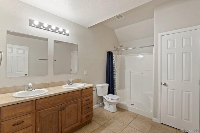 bathroom featuring tile patterned floors, toilet, a textured ceiling, vanity, and curtained shower