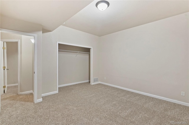 unfurnished bedroom featuring light carpet and a closet