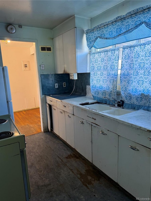 kitchen with electric range, sink, tasteful backsplash, refrigerator, and white cabinets