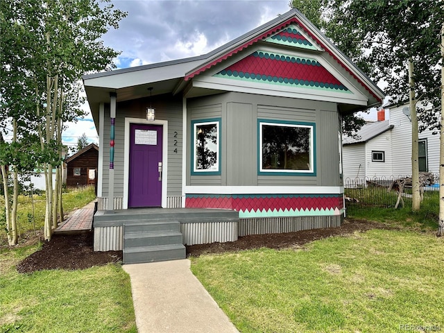 view of front of house with a front yard and fence