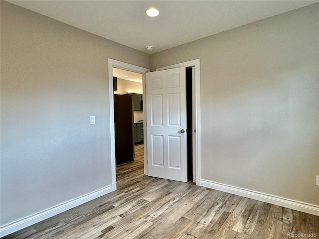 spare room featuring wood finished floors and baseboards