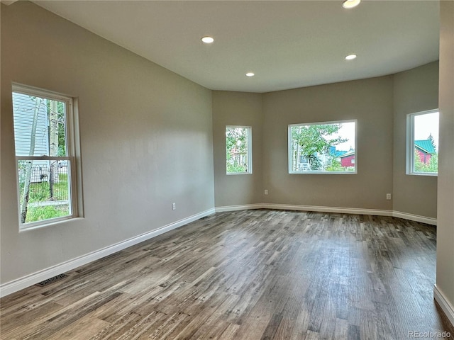 spare room featuring recessed lighting, visible vents, baseboards, and wood finished floors