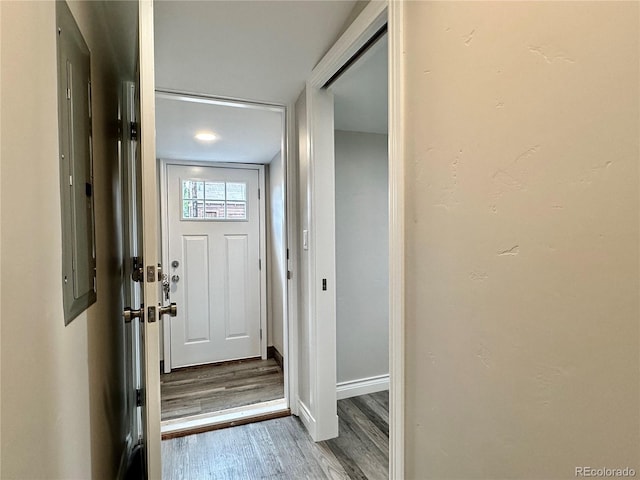 doorway to outside with baseboards and wood finished floors