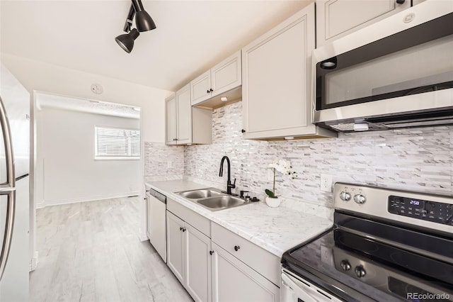 1537 Xenia St, Denver, CO 80220 - kitchen with a sink, tasteful backsplash, appliances with stainless steel finishes, light countertops, and light wood-style floors