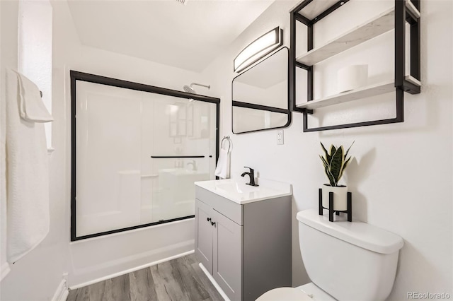1537 Xenia St, Denver, CO 80220 - bathroom featuring bath / shower combo with glass door, toilet, wood finished floors, and vanity