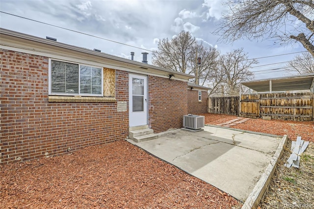 1537 Xenia St, Denver, CO 80220 - rear view of property featuring brick siding, fence, a patio, central AC unit, and entry steps