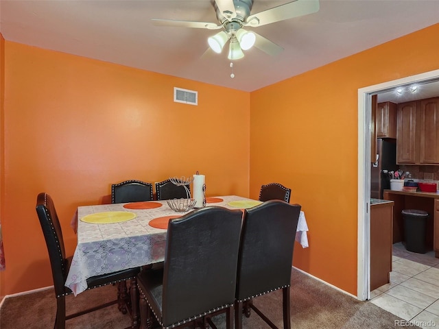 dining area featuring light carpet and ceiling fan