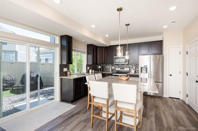 kitchen featuring a center island, dark hardwood / wood-style floors, backsplash, appliances with stainless steel finishes, and sink