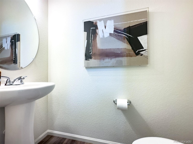 bathroom featuring hardwood / wood-style flooring and toilet