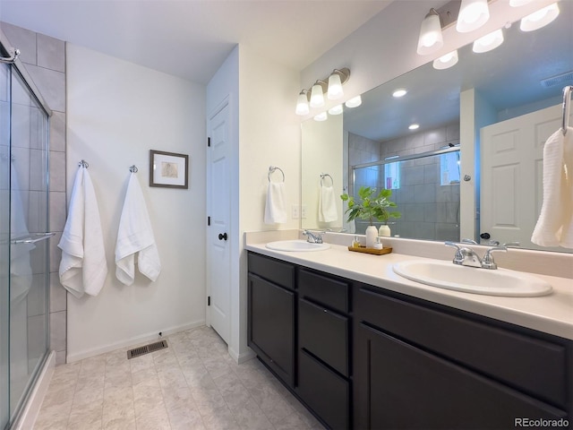 bathroom with a shower with shower door, tile floors, and double vanity