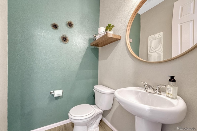 bathroom with hardwood / wood-style flooring, toilet, and sink