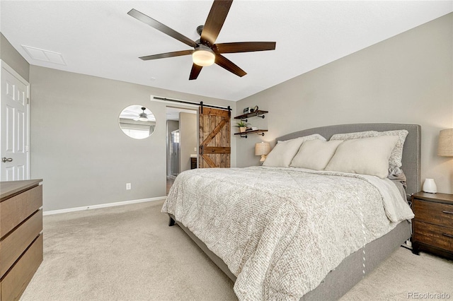 bedroom featuring a barn door, light carpet, and ceiling fan